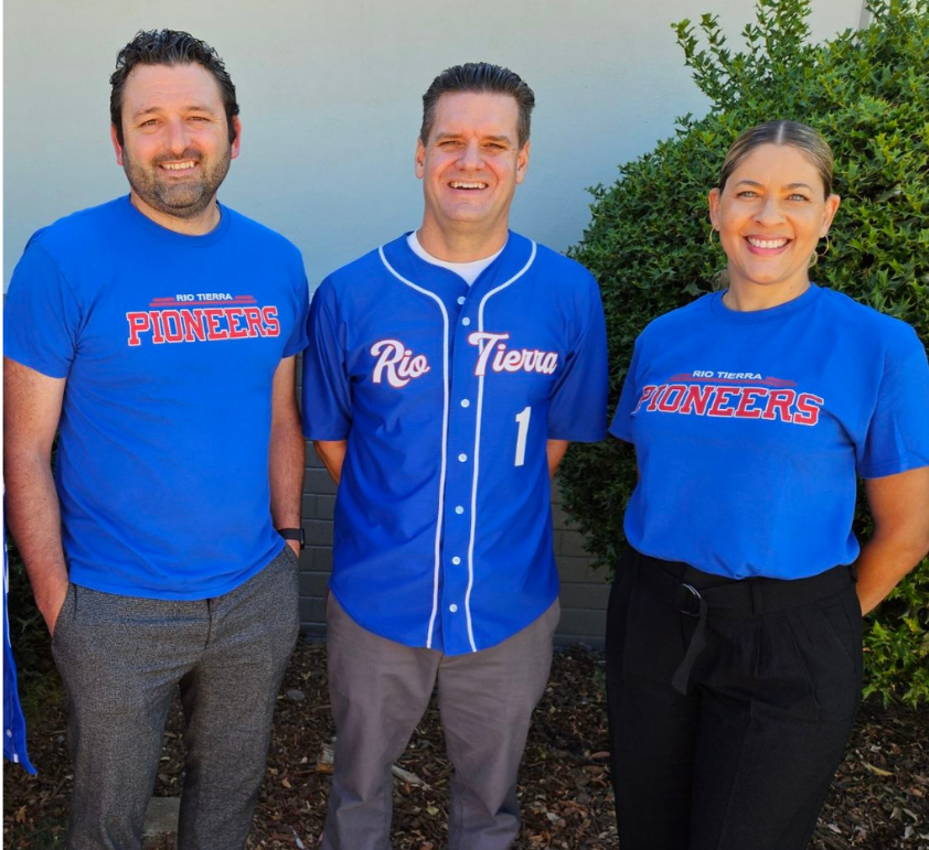 two men in blue rio tierra shirts and one women in a blue rio tierra shirt