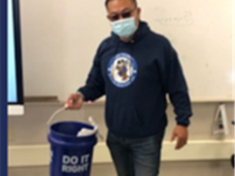 Male teacher with a bucket wearing Rio Tierra sweatshirt